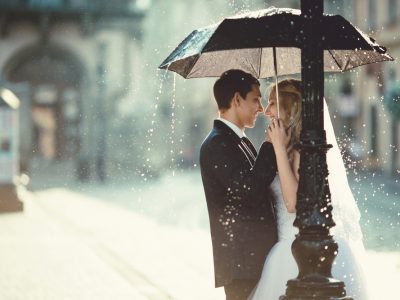 Bride and Groom Standing Under an Umbrella. Howerton+Wooten Events.